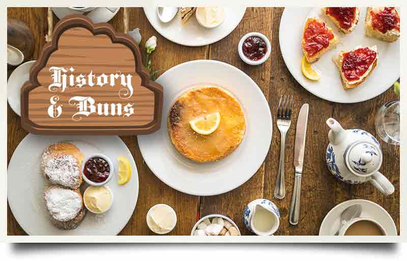Table of food with sign and caption 'History & Buns'.