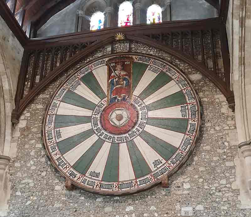 King Arthur's Round Table mounted on the wall below windows.